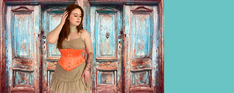 Celebrity wearing a satin waist training corset against a rustic door background 
