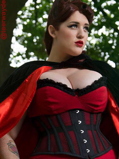 model teer wayde wearing a black cs201 mesh short corset with a red dress and black cape
