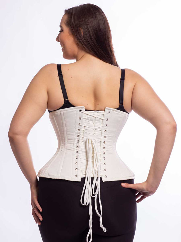 Cute model wearing the extreme curve cs 479 corset in ivory matte satin back lace up view