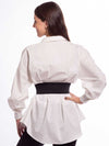 Cute model in a white cotton blouse wearing a black leather corset belt showing the black elastic back