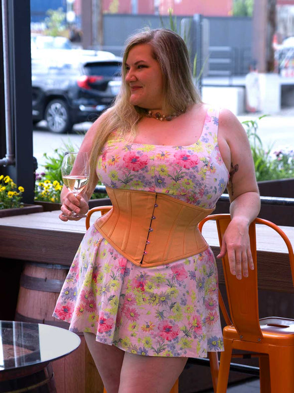 plus size curvy model wearing the cs 201 waist training hourglass curve corset in beige in a floral dress
