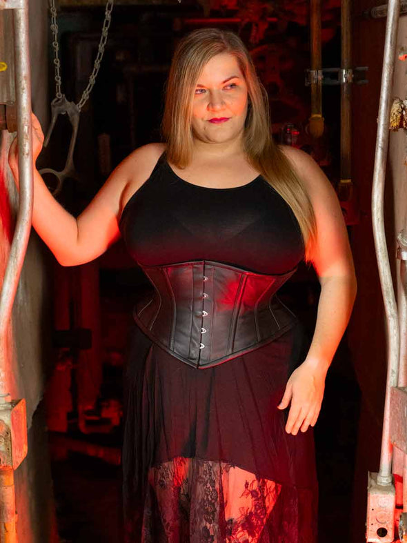 Curvy plus sized model wearing a black strappy dress and a leather cs-201 hourglass curve corset
