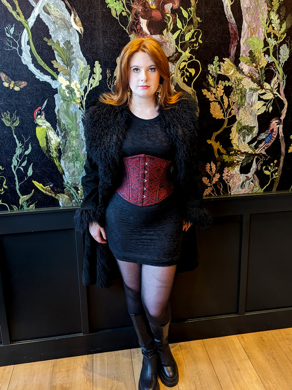 Limited edition red and black valentines corset 220 219 on a model wearing a bodycon dress and fur trimmed coat