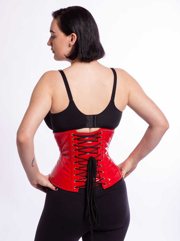 Model wearing the cs411 romantic curve corset in red PVC back lace up view