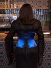 Person wearing a black lace top with a 426 hourglass curve blue corset in a bar setting