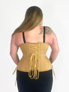 Back lace up corset view of a curvy plus size model wearing a beige corset for waist training and fashion over black leggings and bra