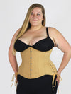 curvy plus size model wearing a beige corset for waist training and fashion over black leggings and bra