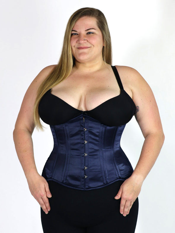 curvy plus size model wearing a black bra and leggings with a navy satin longline corset
