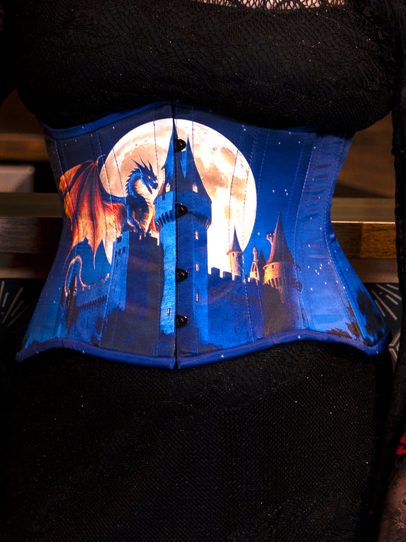 CS426 midnight blue Corset with dragon and castle design on a dark background