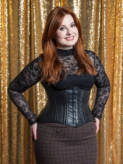 black leather corset with an hourglass shape worn with a plaid skirt and lace top