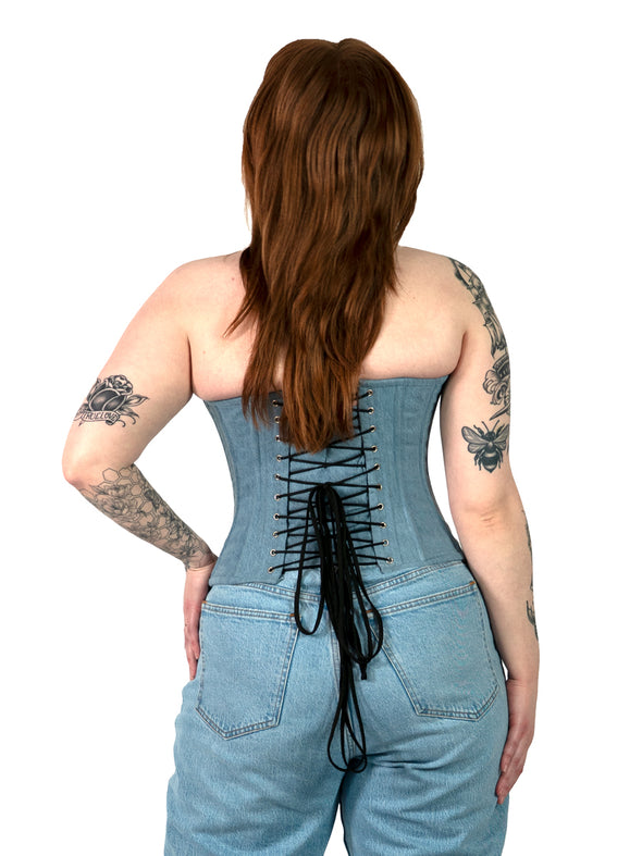 back lace up corset view of cute corset model wearing a denim corset top with blue jeans in LA