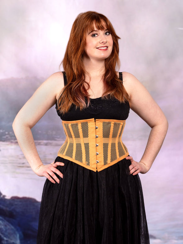 cute corset model wearing a black tulle skirt with a beige mesh cs-201 hourglass curve corset at the beach