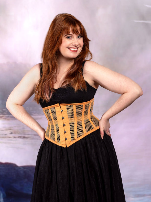 cute corset model wearing a black tulle skirt with a beige mesh cs-201 hourglass curve corset at the beach