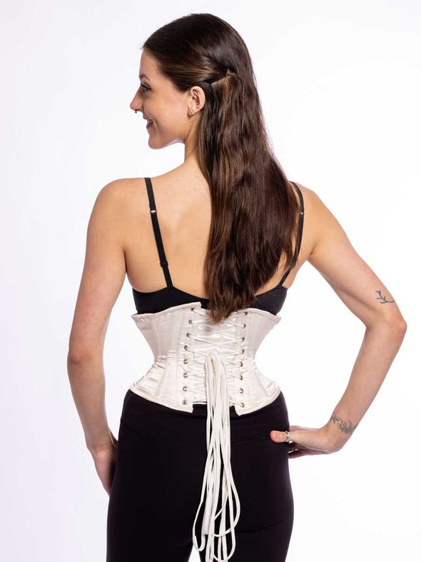 back lace up corset view of a cute corset model wearing a short ivory corset over a black bra and leggings