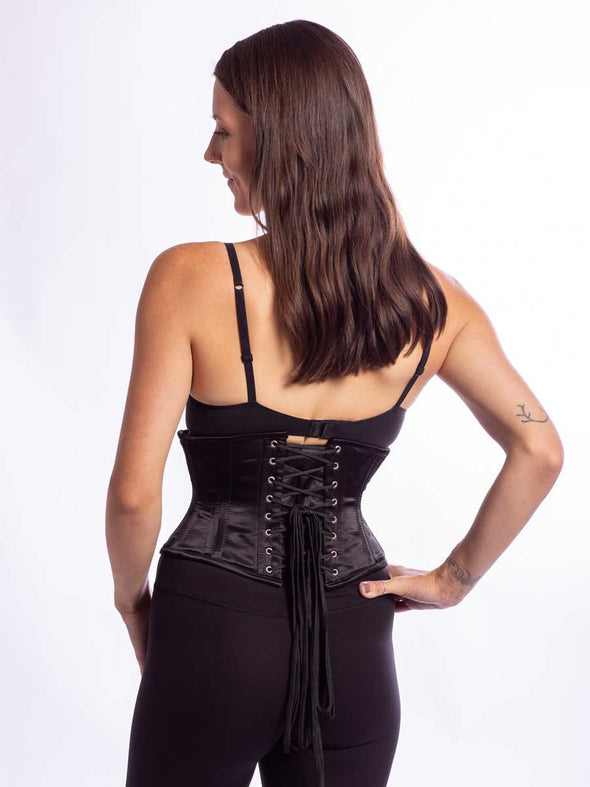 model wearing the new design cs 301 waspie corset in black satin back lace up view