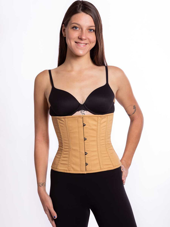 cute model wearing a plus size 305 beige cotton steel boned waist training corset with a black bra and leggings front view
