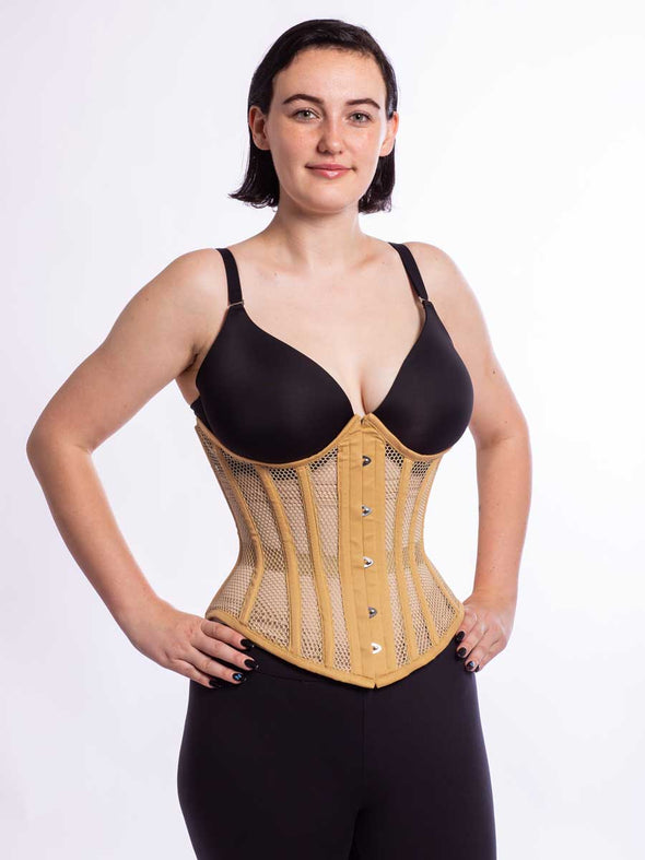 Cute model wearing black leggings and a bra with the CS 345 romantic curve beige mesh steel boned corset front view