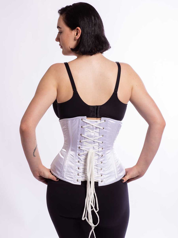 cute model wearing the cs 411 longline romantic curve corset in soft silky white satin back lace up view