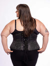 curvy plus size model wearing a black bra and leggings and a black brocade corset back lace up view