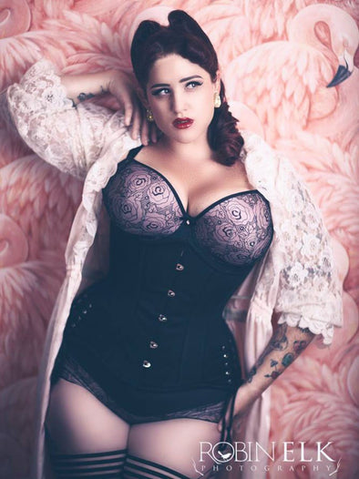 Teer Wade in the 426 hourglass curve longline corset with hip ties shown with rose print lingerie on pink background