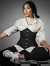 pouty model wearing a black cotton corset over black jean and a shimmery shirt