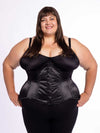 curvy plus sized model wearing black legging and bra with a black satin corset standing with her hands on her hips