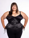cute curvy plus size corset model wearing a black satin corset with hip ties over a black bra and leggings