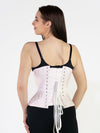 Smiling model wearing black leggings and a black bra completing the outfit with a pale pink hourglass curve satin corset back lace up corset view