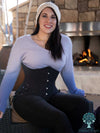 Dark haired model wearing a purple Ombre sweater and black jeans with a hourglass curve corset with hip ties