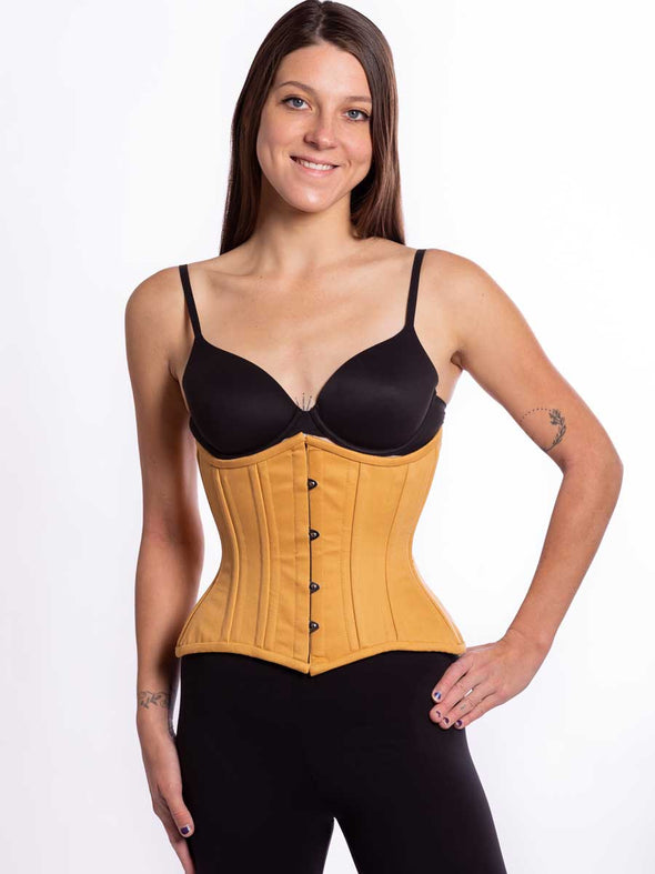 Curvy beige cotton corset worn by a female model over black leggings and black bra