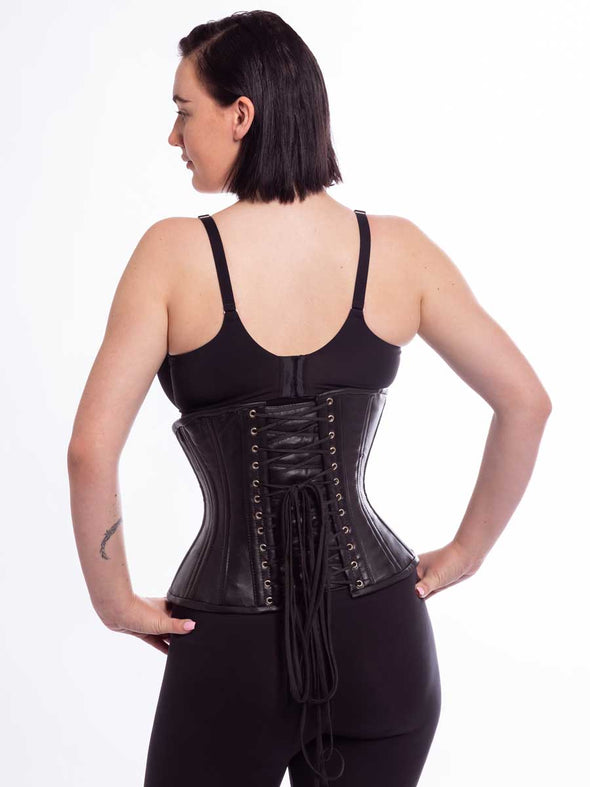 Beautiful black leather curvy cs426 corset on a female model hands on hips back lace up detail view
