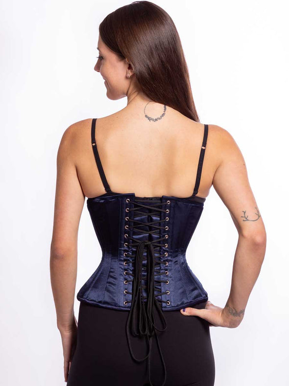 Back lace up detail of a Curvy navy corset being worn by a female model with black leggings and a black bra