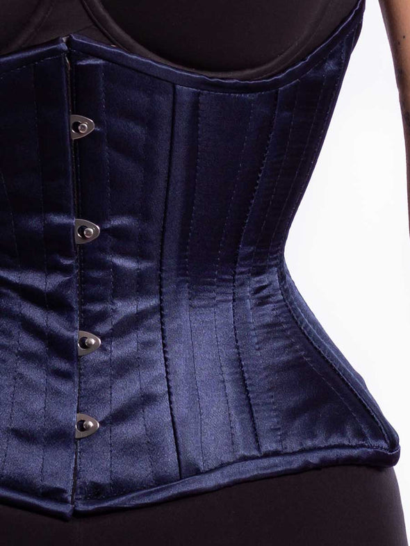 Front detail view of a Curvy navy corset being worn by a female model with black leggings and a black bra