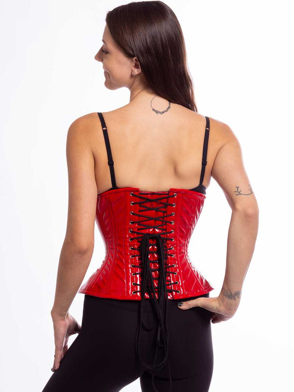 Smiling model wearing the cs426 hourglass curve corset in shiny red latex pvc back lace up detail