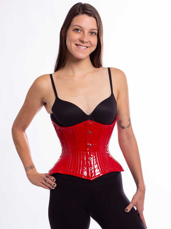 Smiling model wearing the cs426 hourglass curve corset in red latex pvc front busk view
