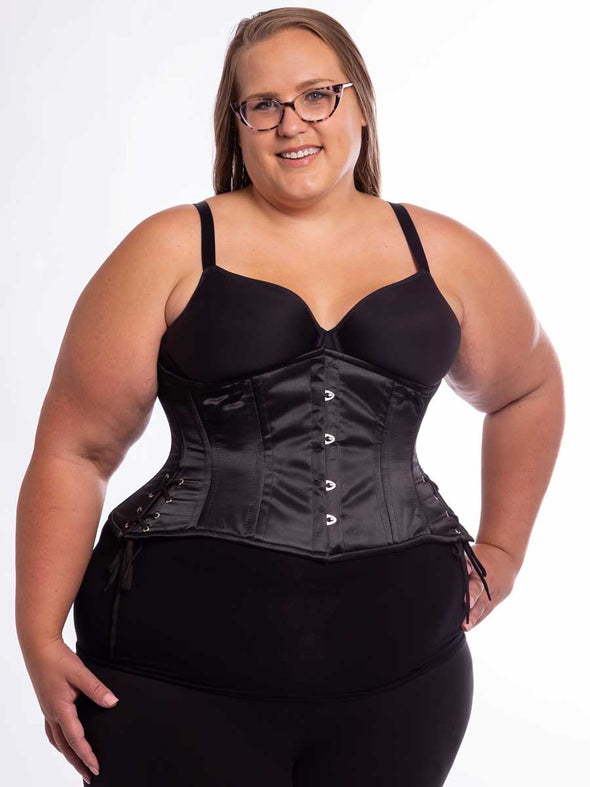 Curvy plus size model wearing black leggings and black bra with the black satin cs426 with hip ties