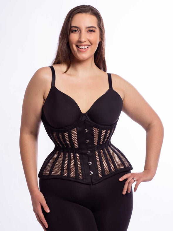 Smiling model wearing the extreme curve cs479 waist training corset in black mesh