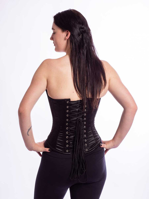 Cute model wearing the cs530 corset top in black satin back lace up view