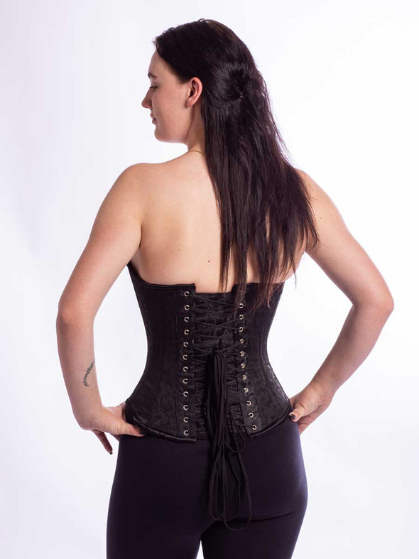 Smiling model wearing the cs530 black brocade corset top back lace up view