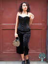 Model wearing the 530 overbust with black velvet pants and holding a leopard print purse