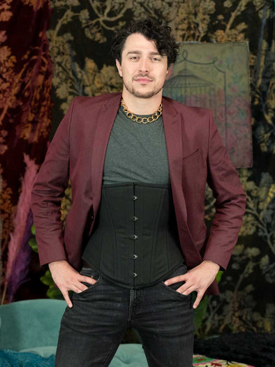Male model wearing jeans, tshirt and jacet with a black cotton corset under the jacket