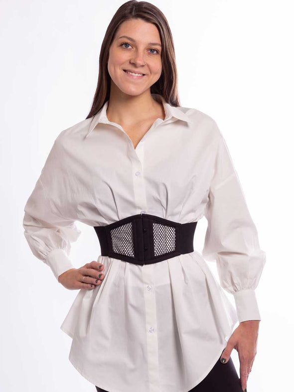 Model wearing a black mesh corset belt over a cotton shirt and leggings