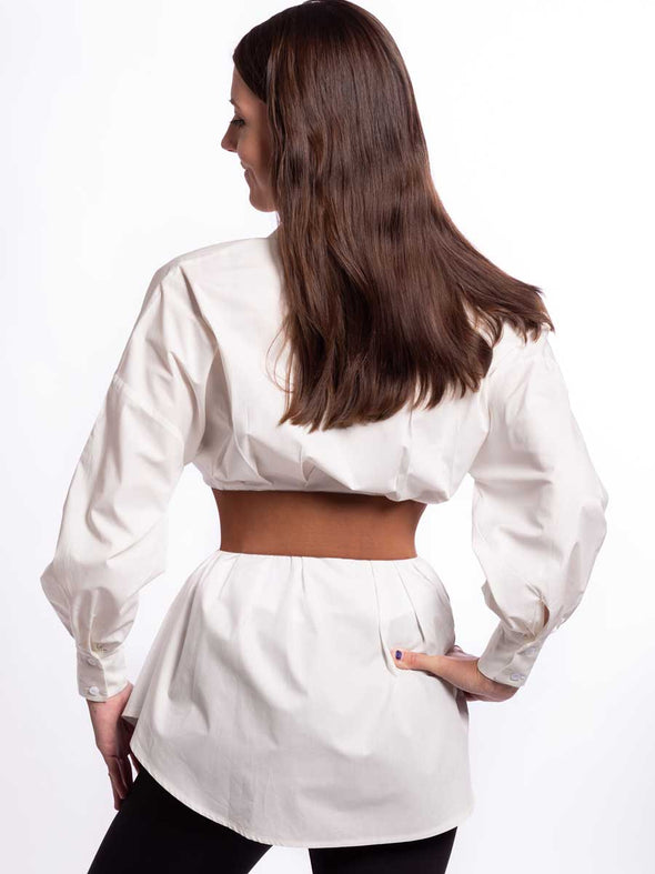 Cute model in a white cotton blouse wearing a brown leather corset belt back view