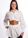 Cute model in a white cotton blouse wearing a brown leather corset belt