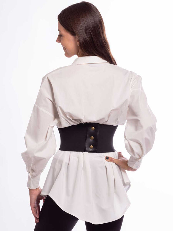 Model wearing a white tunic and black leggings with a wide faux lace up corset belt showing the snap closure in the back