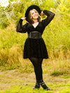 Cute model wearing a black dress and boots with a lace up corset belt accessory 