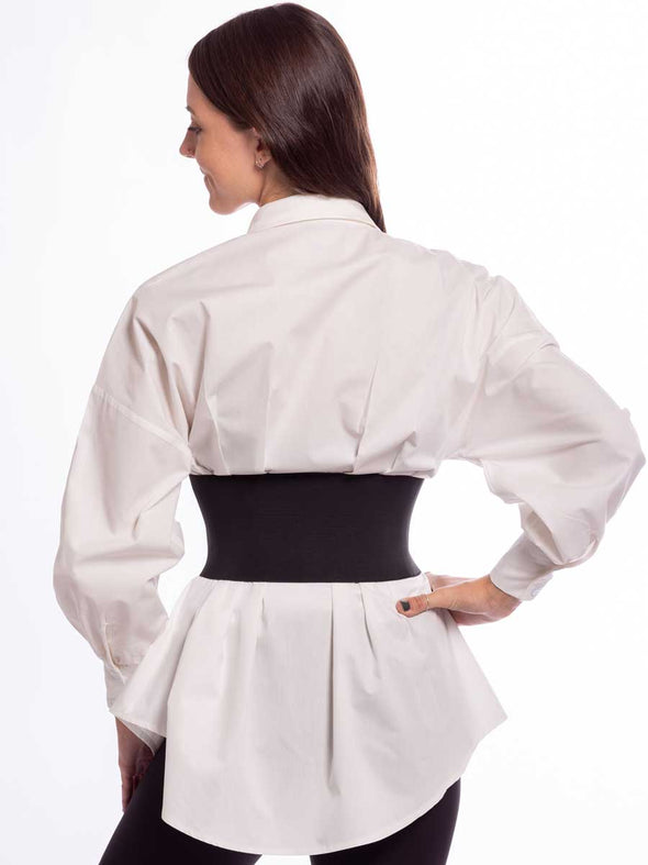 Woman in a white tunic with a black steampunk best with buckles and snaps back view