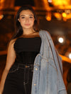 Model wearing a black chiffon and satin cropped fashion corset top with dark jeans and a washed jean jacket