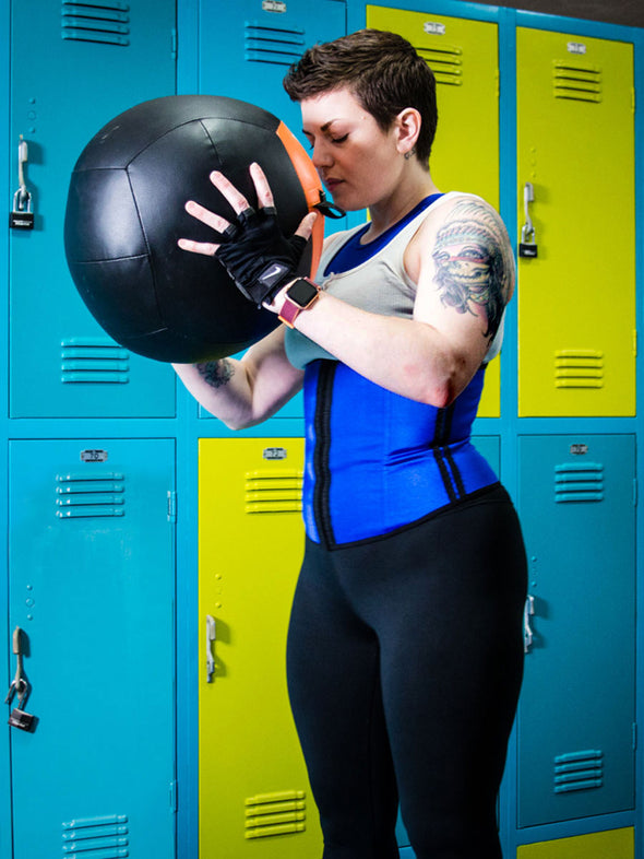 Model holding a medicine ball wearing workout shapewear with leggings and a sports bra